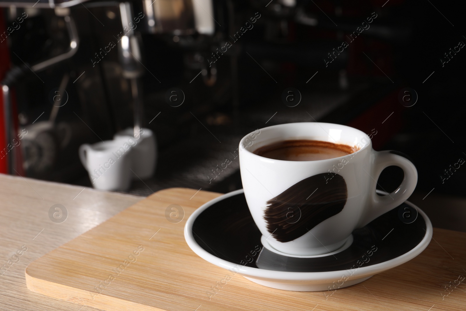 Photo of Cup of fresh aromatic espresso on wooden table in cafe, space for text