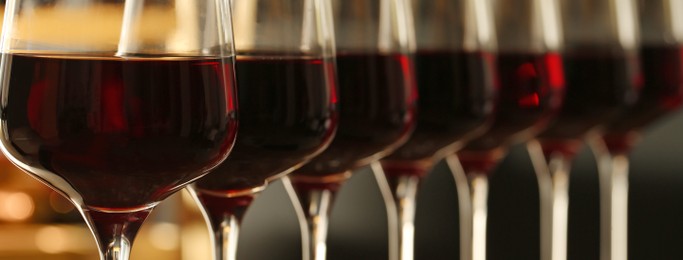 Glasses with tasty red wine, closeup view. Banner design