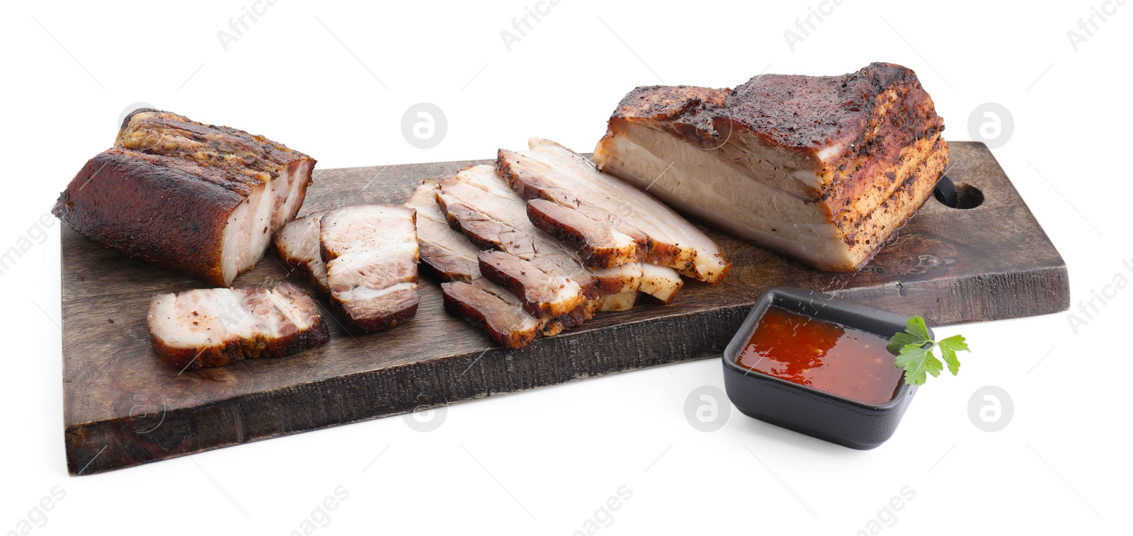 Photo of Pieces of tasty baked pork belly and sauce isolated on white