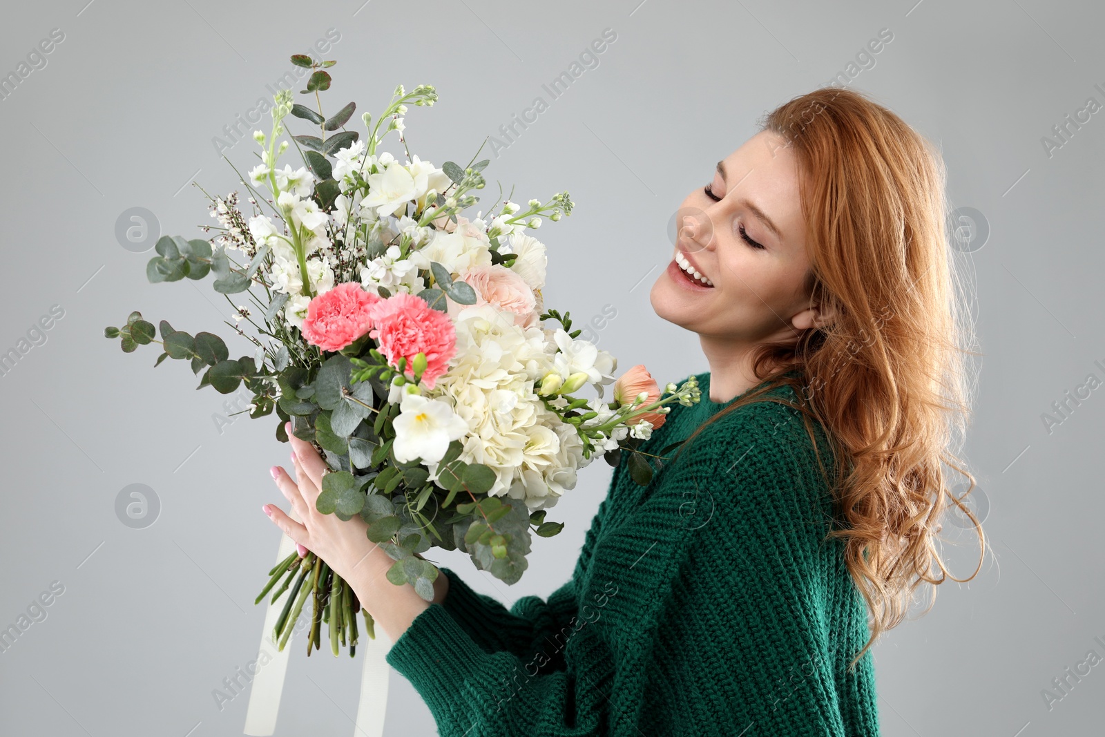 Photo of Beautiful woman with bouquet of flowers on grey background