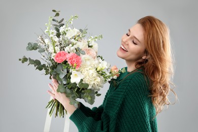 Photo of Beautiful woman with bouquet of flowers on grey background