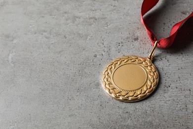 Photo of Gold medal with space for design on grey background. Victory concept