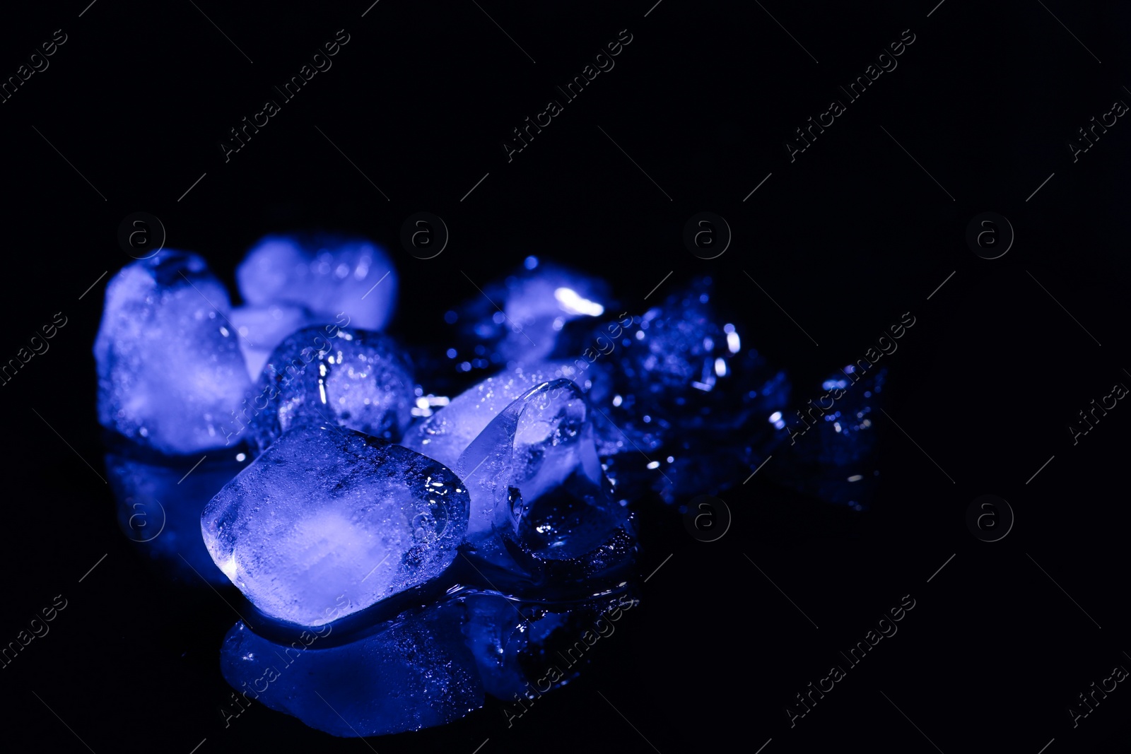 Photo of Melting ice cubes on black background. Space for text