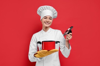 Photo of Professional chef with cooking pot on red background