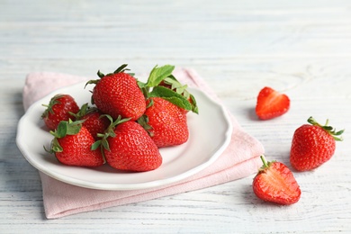 Plate with ripe red strawberries and mint on table