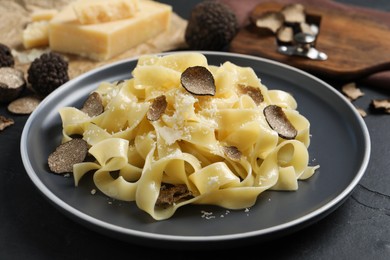 Photo of Tasty tagliatelle with truffle on black table