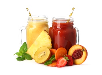 Mason jars of delicious juices and fresh ingredients on white background