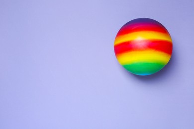 Photo of New bright kids' ball on lilac background, top view. Space for text