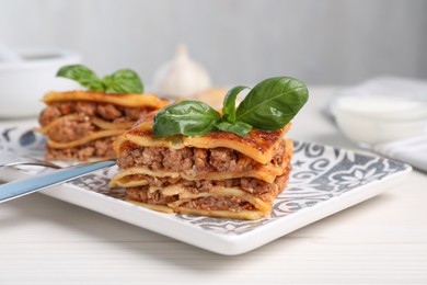 Photo of Delicious lasagna served on white table, closeup