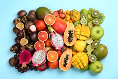 Photo of Many different delicious exotic fruits on light blue background, flat lay