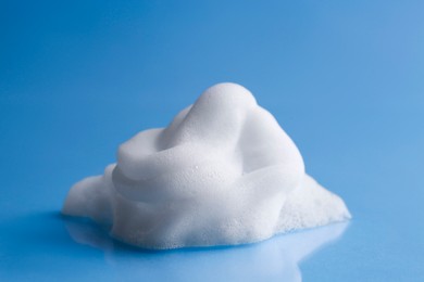 Fluffy white foam on light blue background