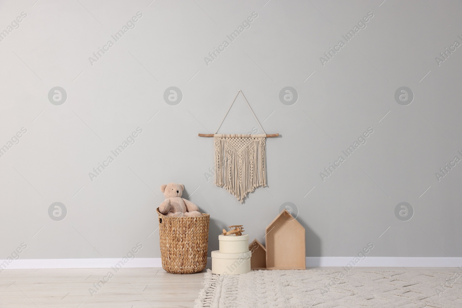 Photo of Beautiful children's room with grey wall, decor elements and toys. Interior design