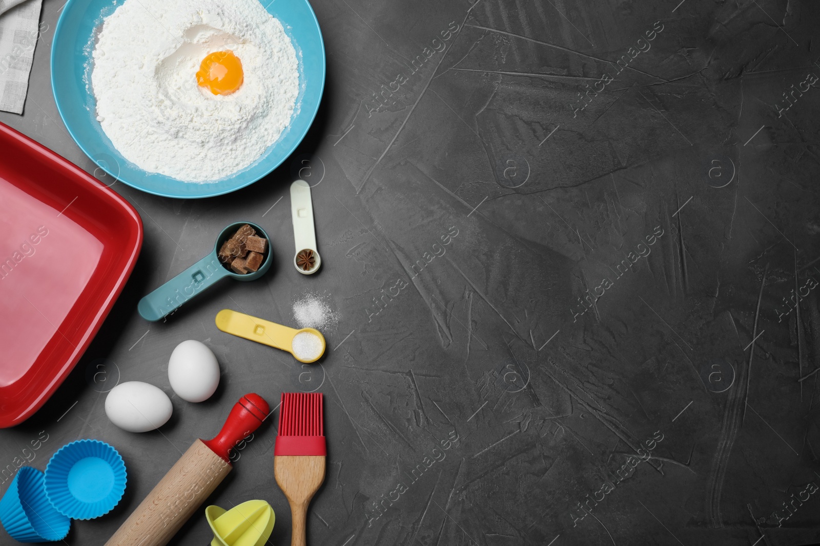 Photo of Cooking utensils and ingredients on black table, flat lay. Space for text