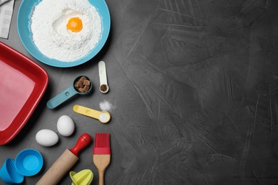 Photo of Cooking utensils and ingredients on black table, flat lay. Space for text