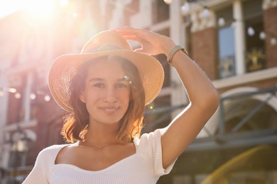 Portrait of happy young woman outdoors on sunny day