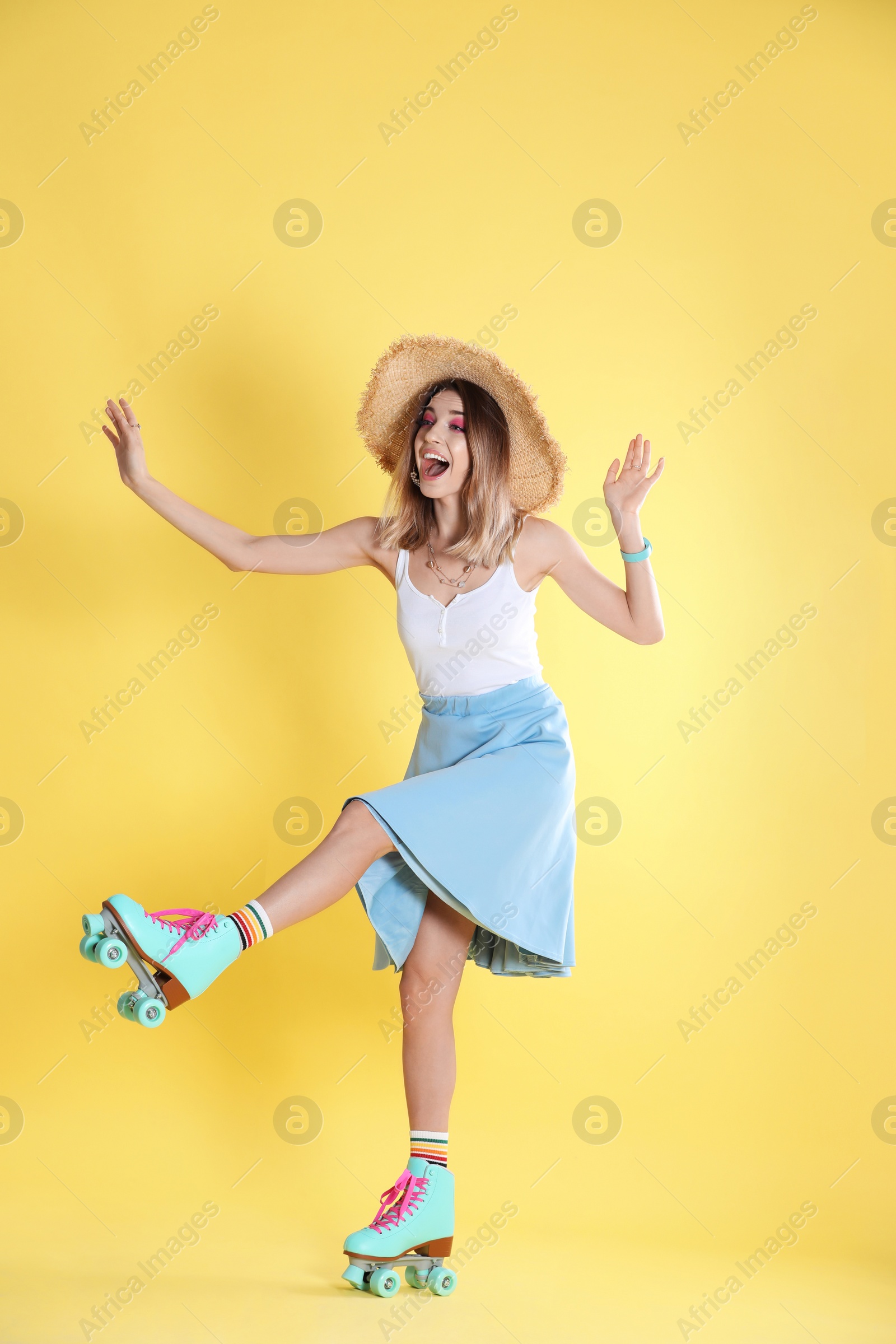 Photo of Young woman with retro roller skates on color background