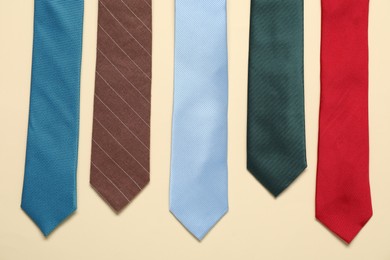 Different neckties on beige background, flat lay