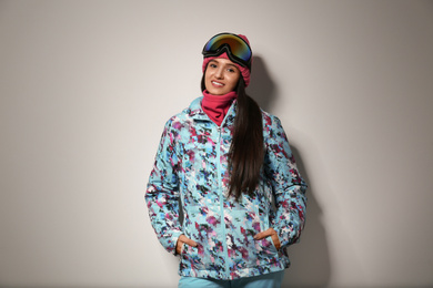 Photo of Woman wearing stylish winter sport clothes on light grey background