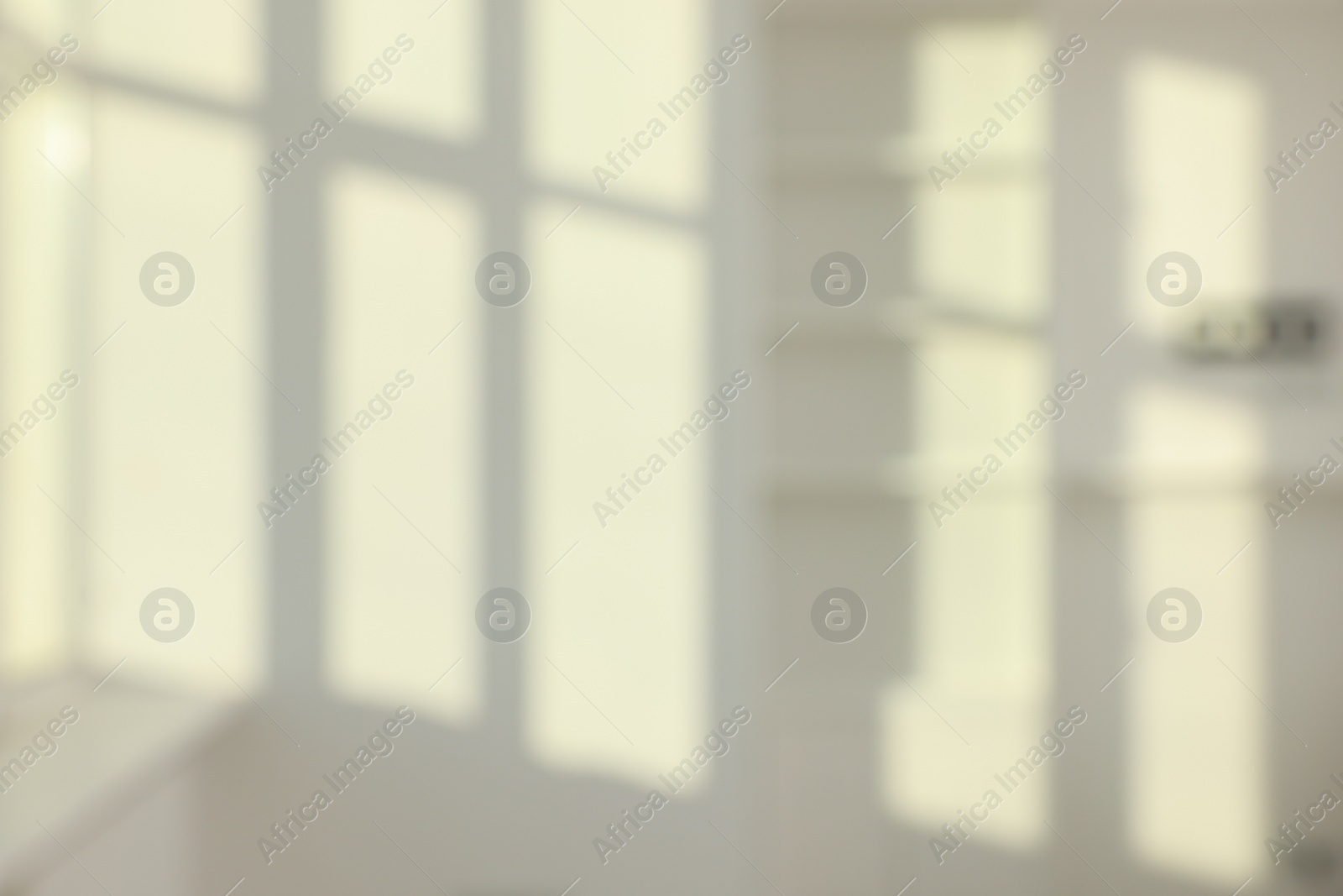 Photo of Blurred view of light and shadows from window on wall indoors