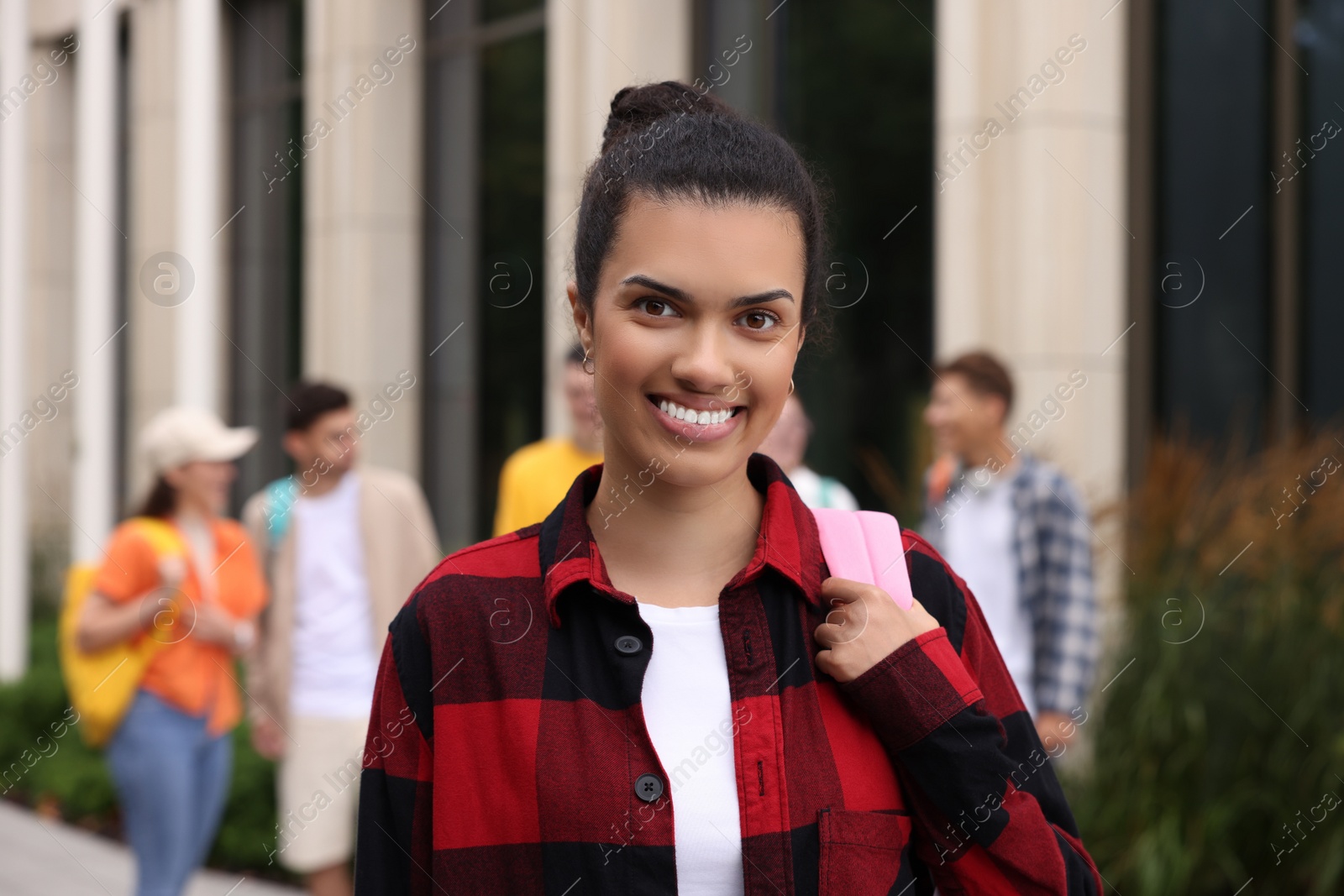 Photo of Happy student with backpack outdoors, selective focus