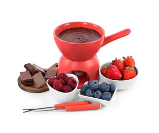 Photo of Fondue pot with melted chocolate, fresh berries and forks isolated on white