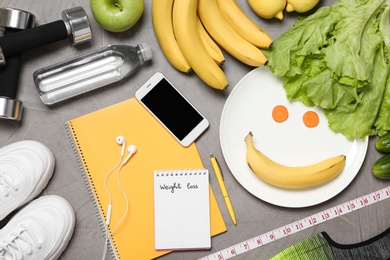 Photo of Flat lay composition with sport equipment and mobile phone on gray background. Weight loss