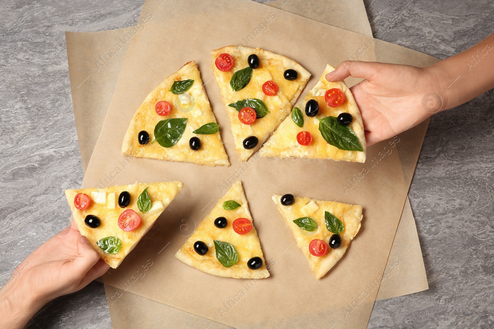 Photo of People taking tasty homemade pizza slices from table, top view