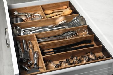 Different utensils in open desk drawer indoors