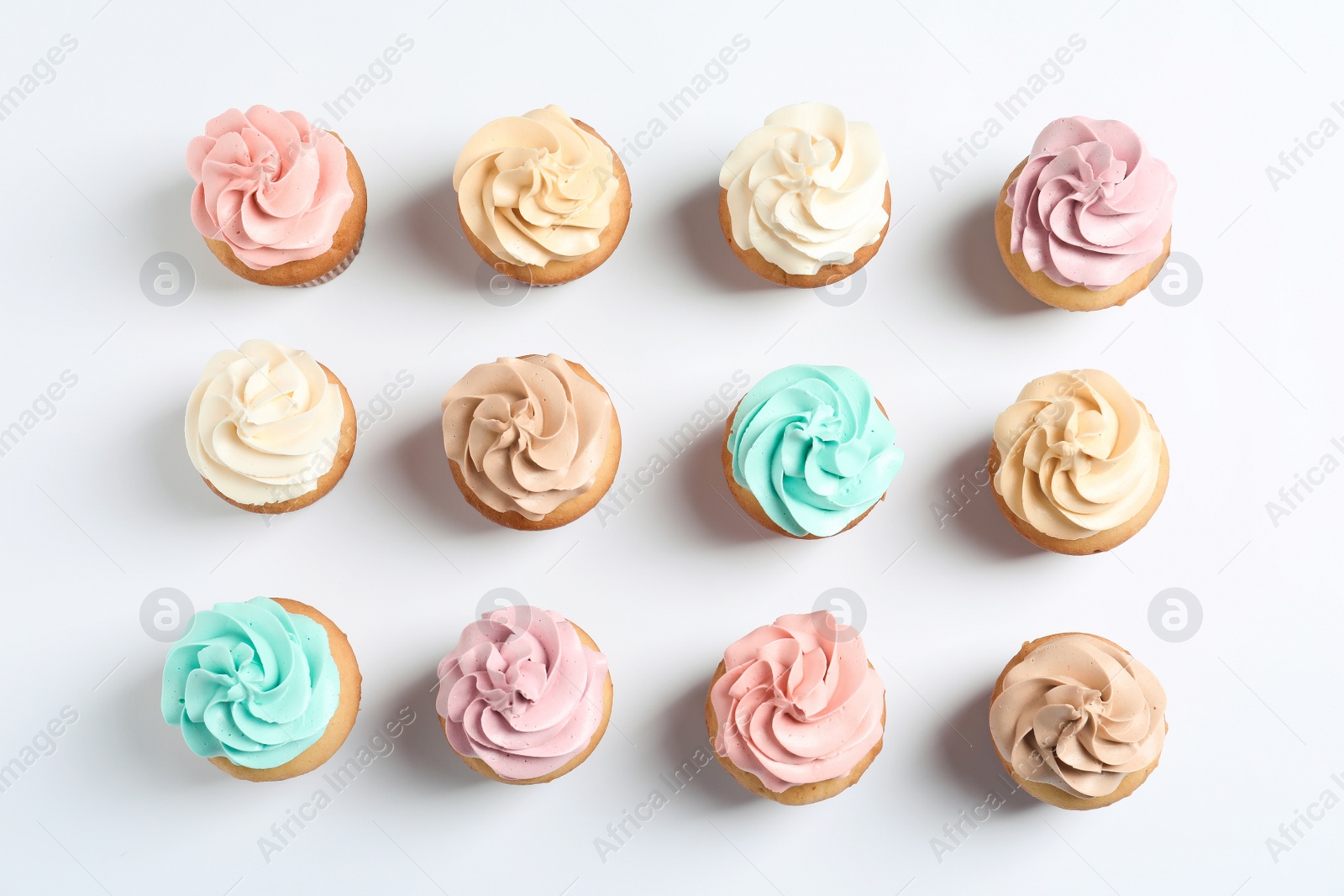 Photo of Flat lay composition with delicious birthday cupcakes on white background