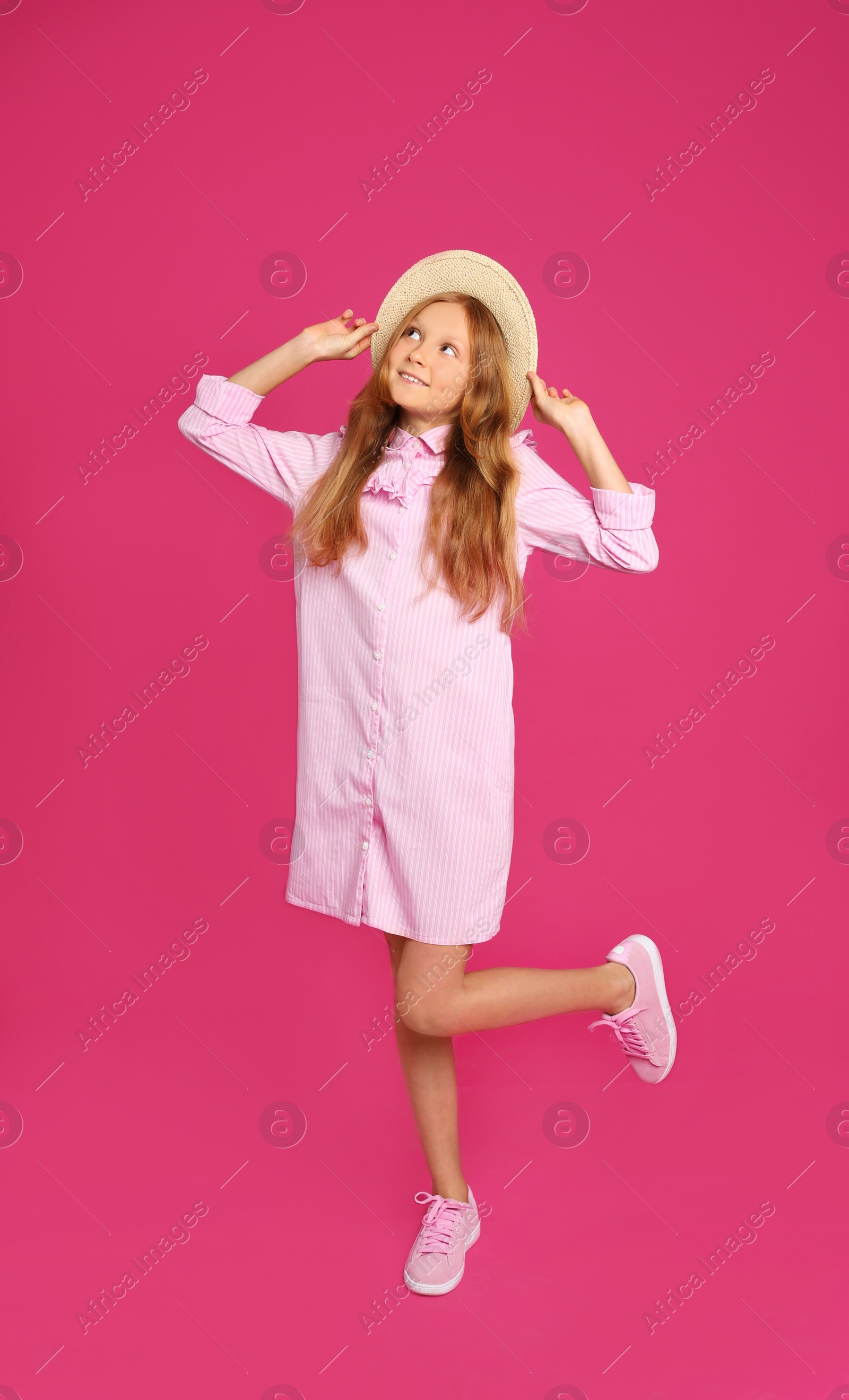 Photo of Full length portrait of preteen girl in hat on pink background