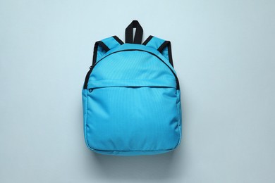 Photo of Stylish blue backpack on light background, top view