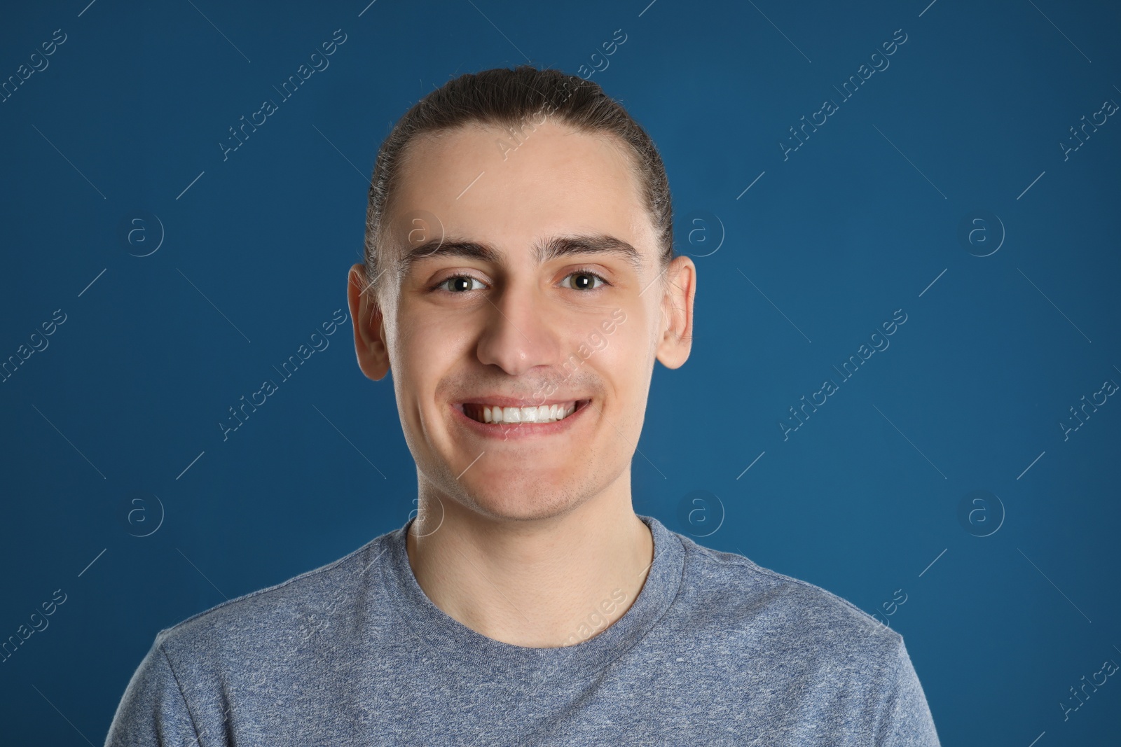 Photo of Portrait of happy young man on blue background