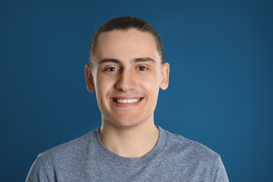 Portrait of happy young man on blue background