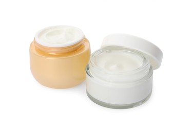 Photo of Jars of face cream on white background