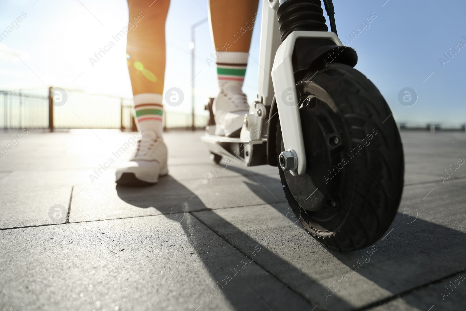 Photo of Woman with kick scooter on city street, closeup