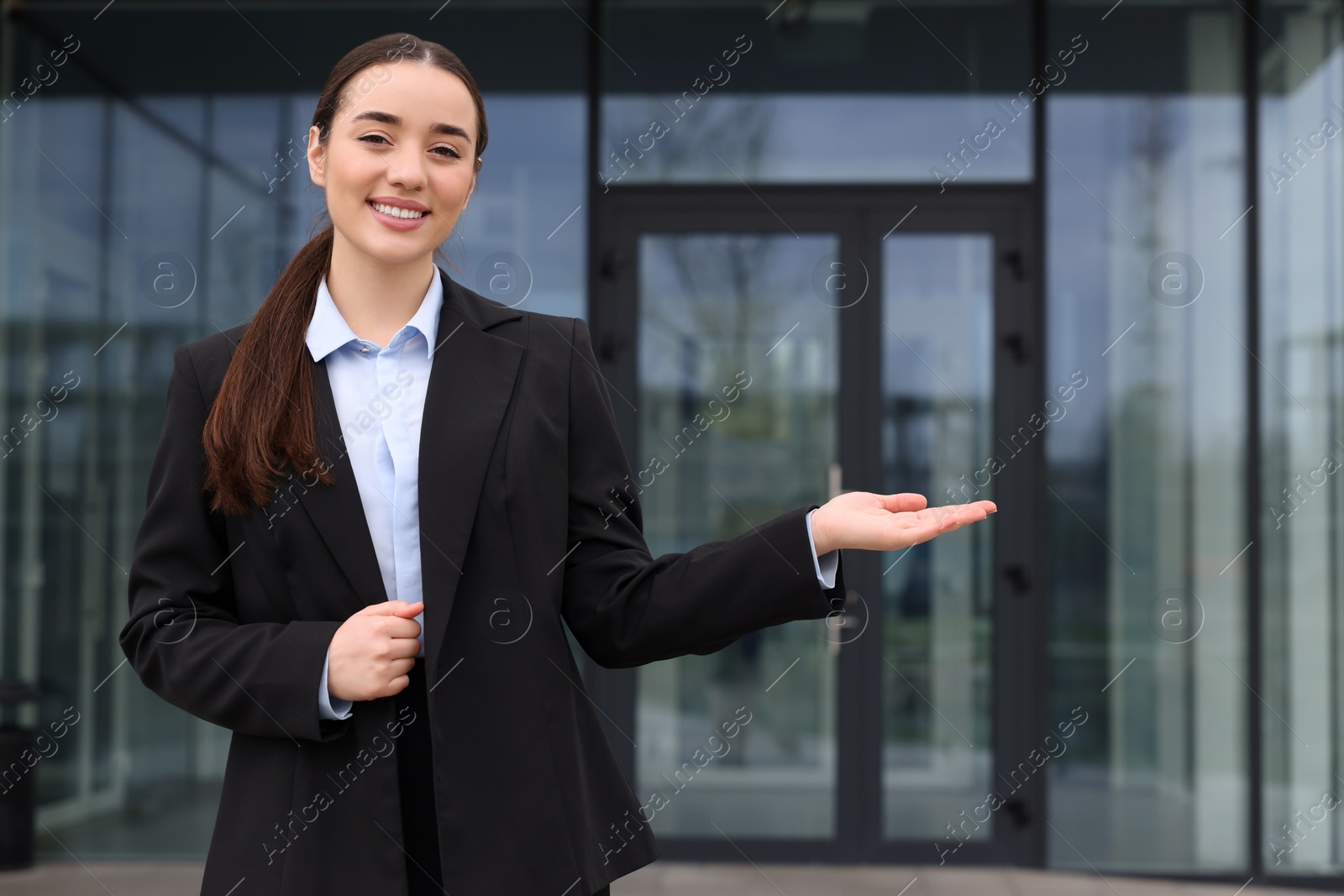 Photo of Happy real estate agent in suit outdoors