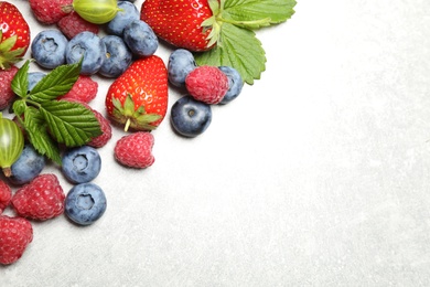 Photo of Mix of fresh berries on light table, flat lay. Space for text