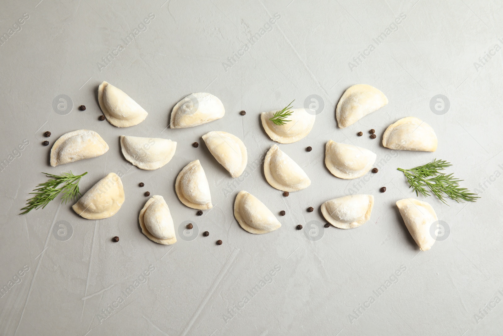 Photo of Flat lay composition with raw dumplings on grey background