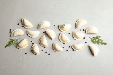 Flat lay composition with raw dumplings on grey background