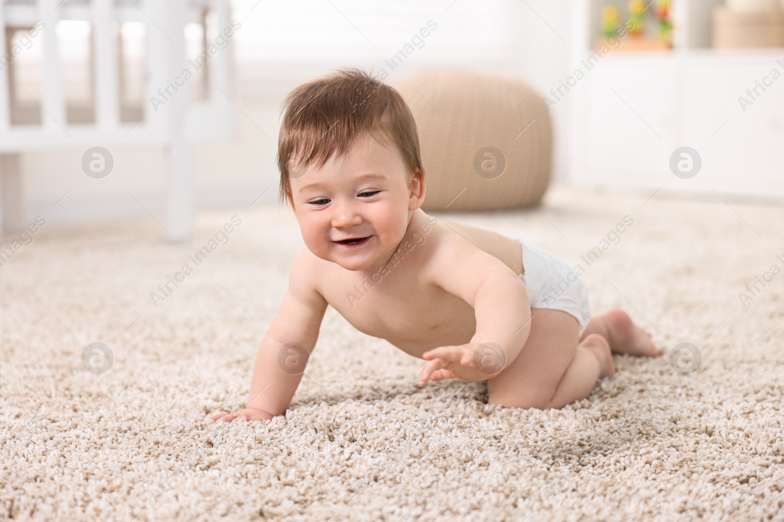 Photo of Cute baby boy crawling on carpet at home