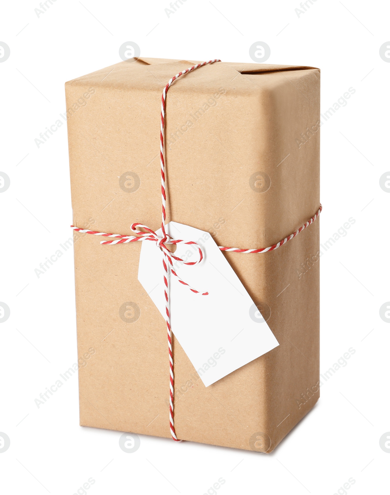 Photo of Gift box wrapped in kraft paper with bow and tag isolated on white