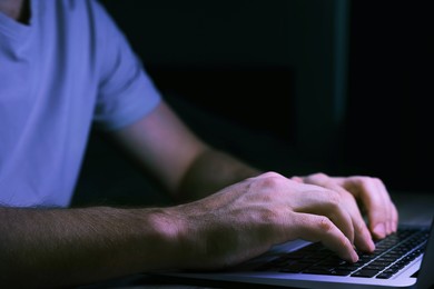 Photo of Man using computer at night, closeup. Internet addiction