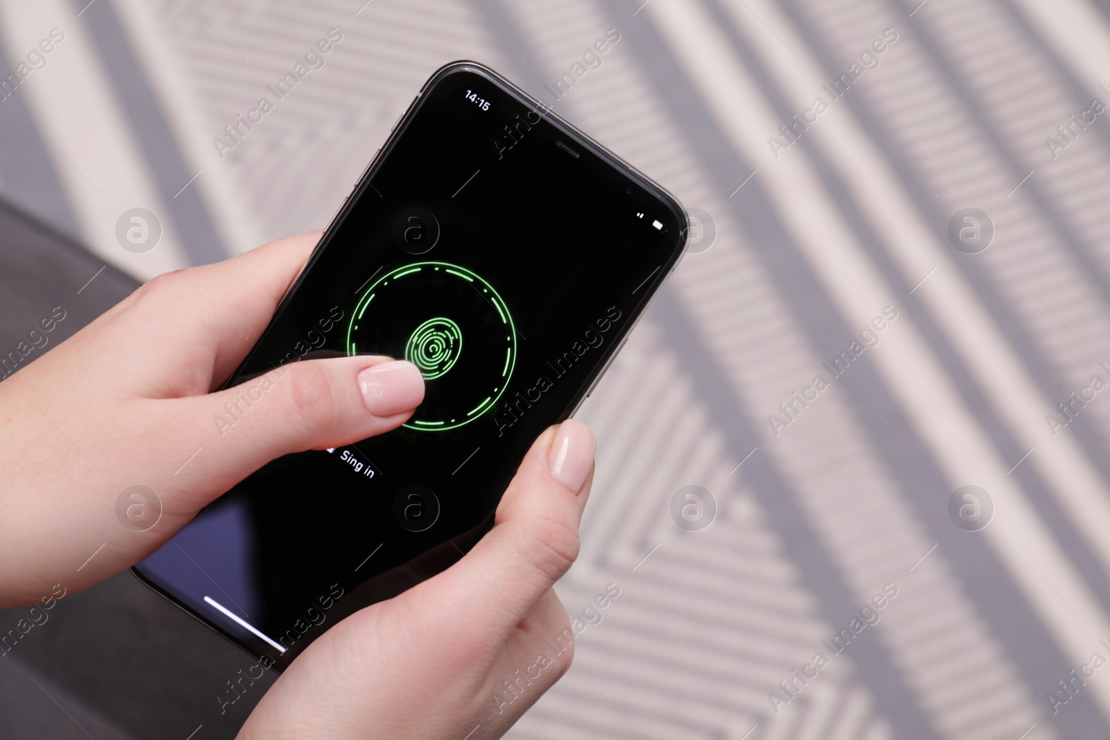 Photo of Woman unlocking smartphone with fingerprint scanner indoors, closeup