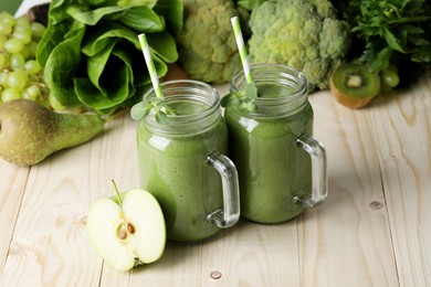 Photo of Mason jars of fresh green smoothie and ingredients on wooden table