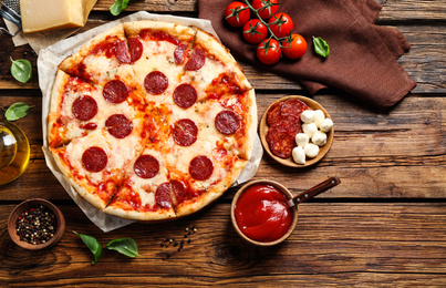 Photo of Flat lay composition with hot pepperoni pizza on wooden table
