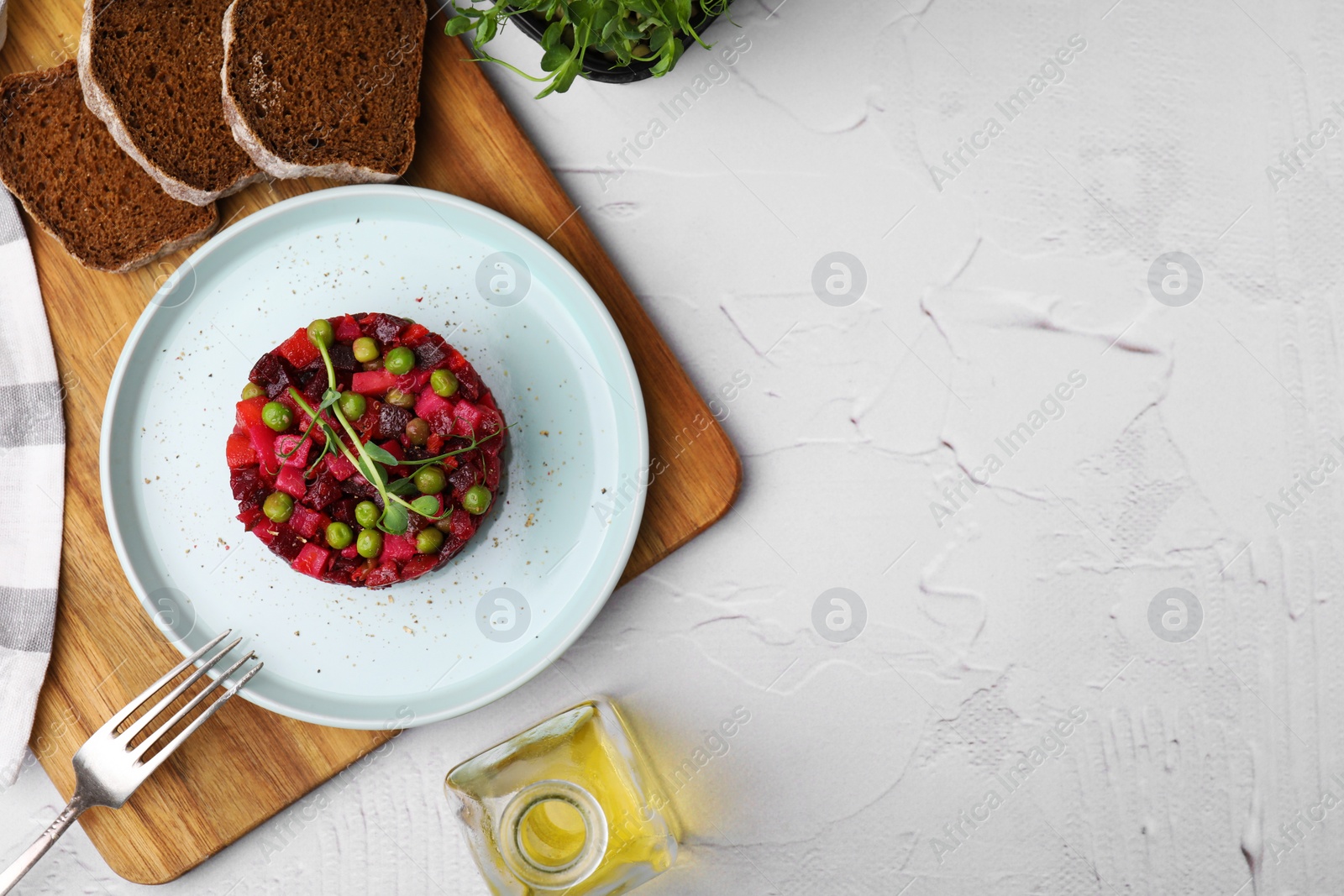 Photo of Delicious vinaigrette salad and slices of bread on white textured table, flat lay. Space for text