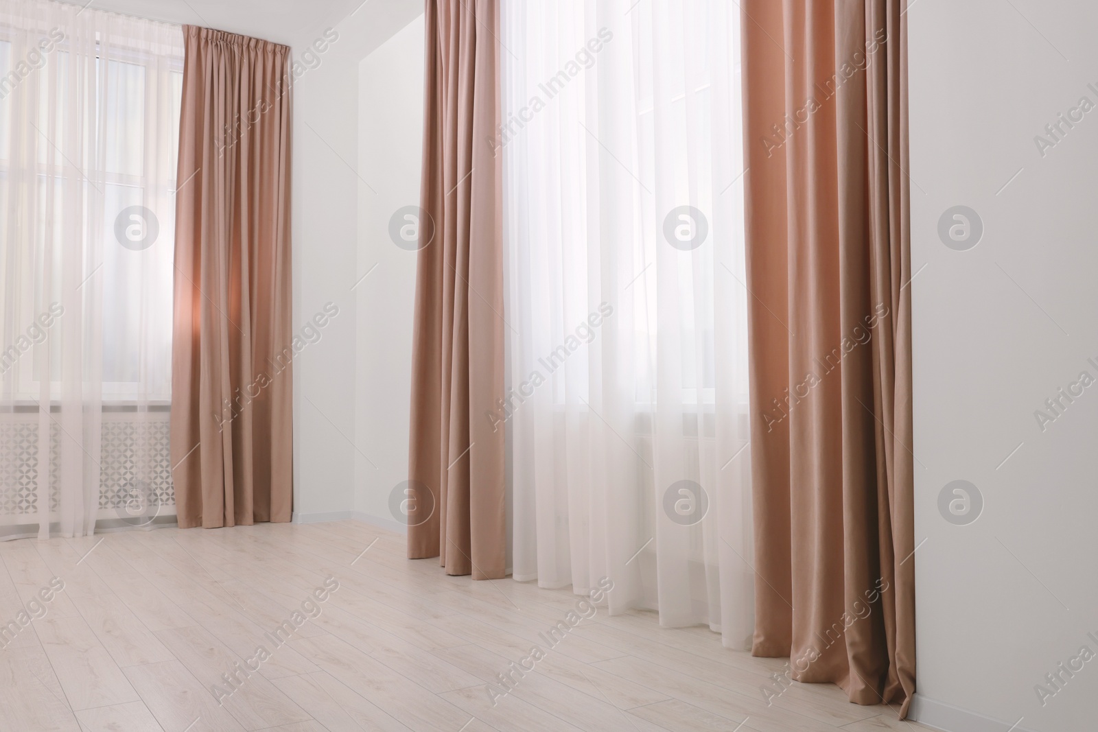 Photo of Elegant window curtains and white tulle indoors. Interior design