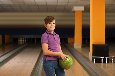 Photo of Preteen boy with ball in bowling club
