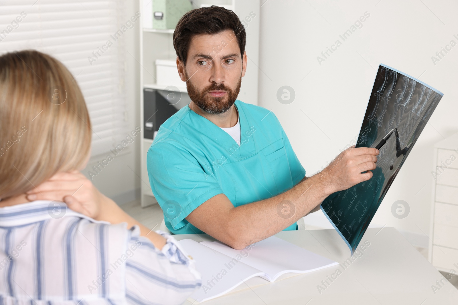 Photo of Doctor with neck MRI scan consulting patient in hospital