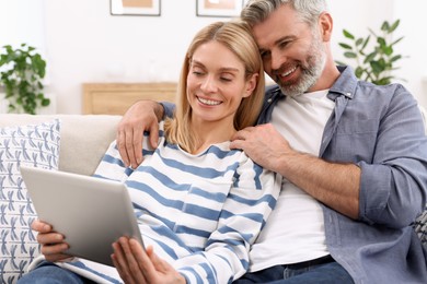 Photo of Happy affectionate couple with tablet at home. Romantic date